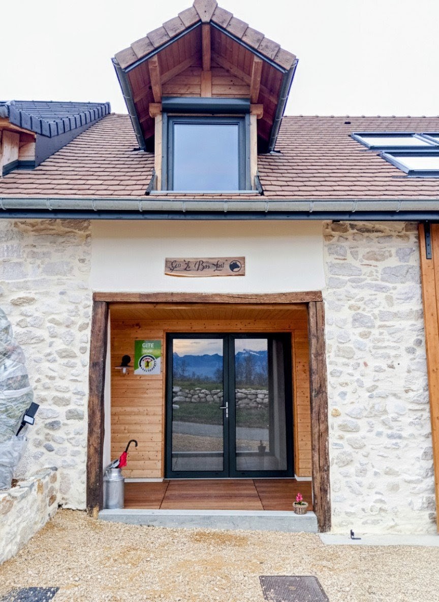 Chalet in the mountains with a stone exterior and a brown tiled roof. Gîte Bon-Heu.